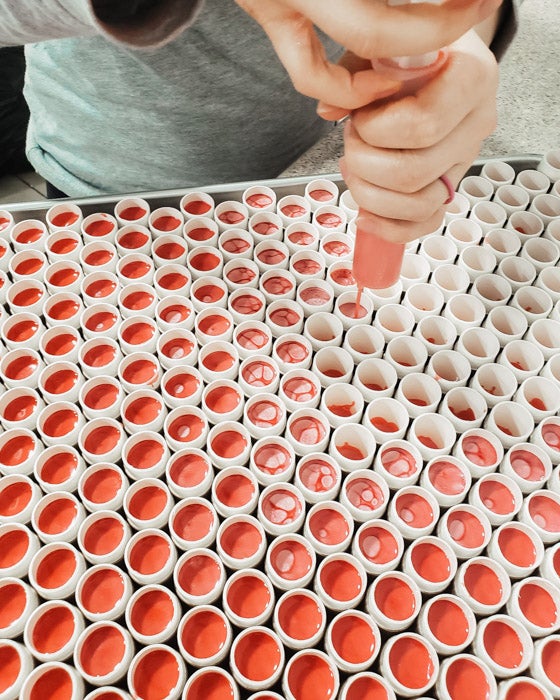 Filling vegan lip balm packaging by hand
