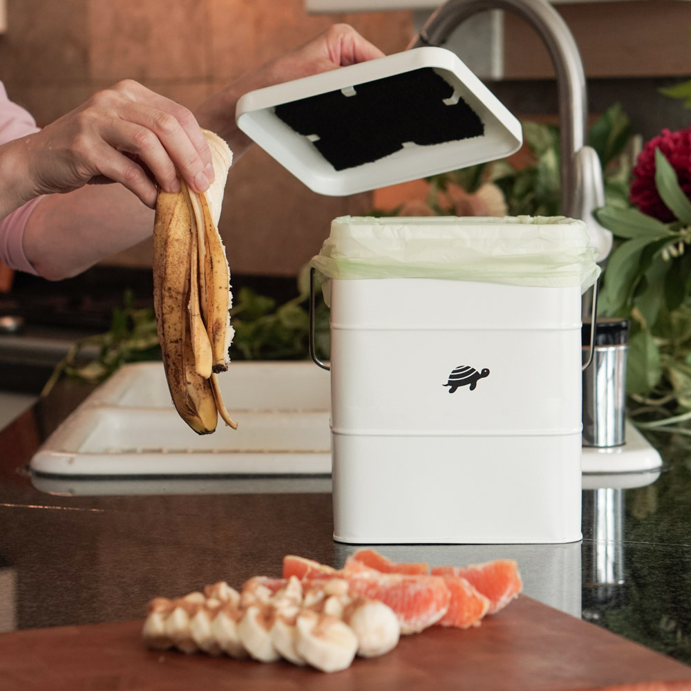 food scraps being thrown into Net Zero Co.'s Kitchen Compost Bin