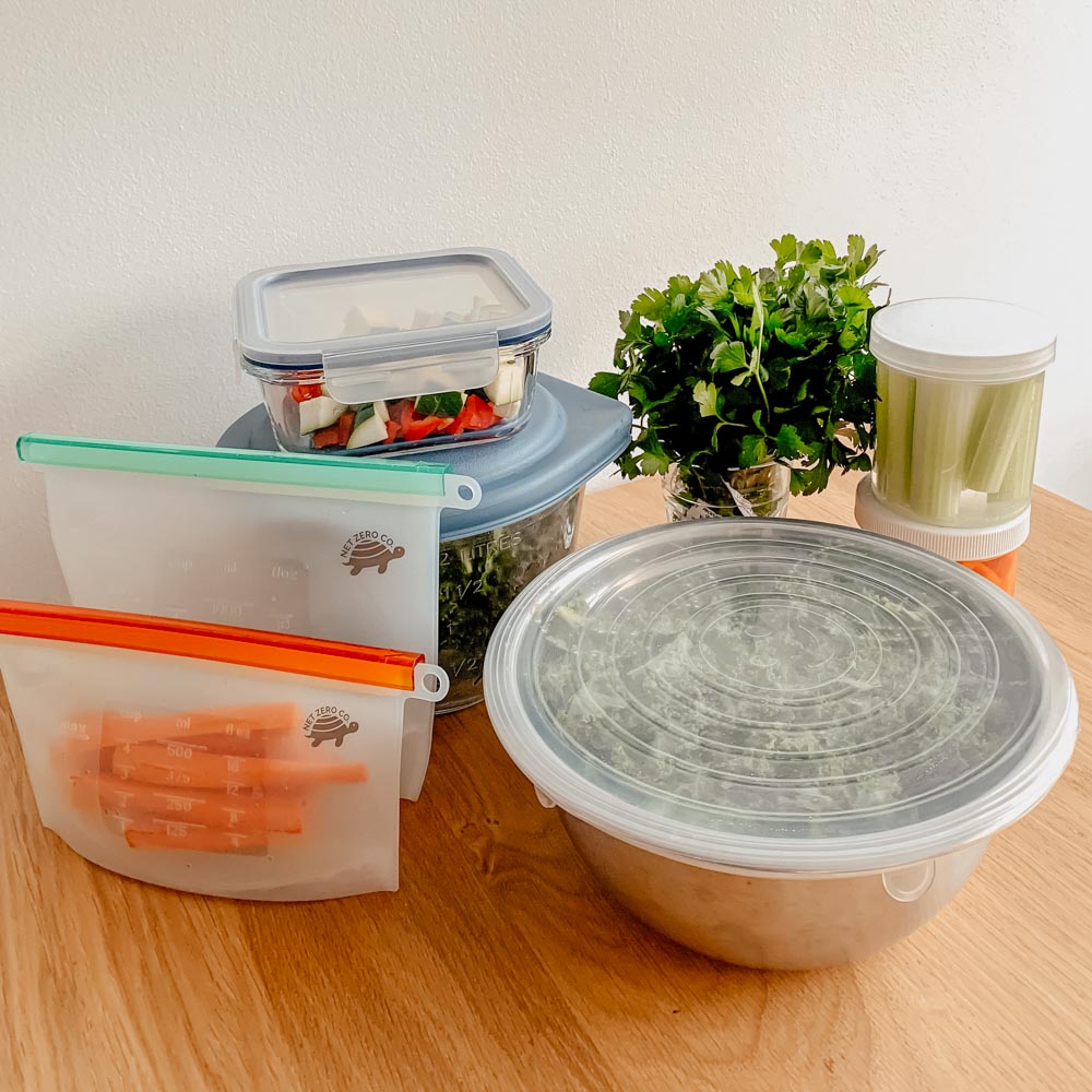 Meal prep veggies in sealers and kale in bowl with stretch and seal lid.