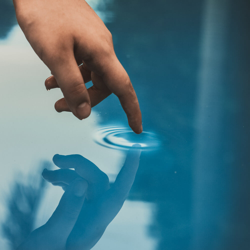 Why your actions matter blog cover. Hand creating a ripple in the water.