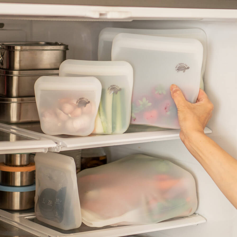 Hand pulling large Silicone Zip Sealer with strawberries out of the fridge.