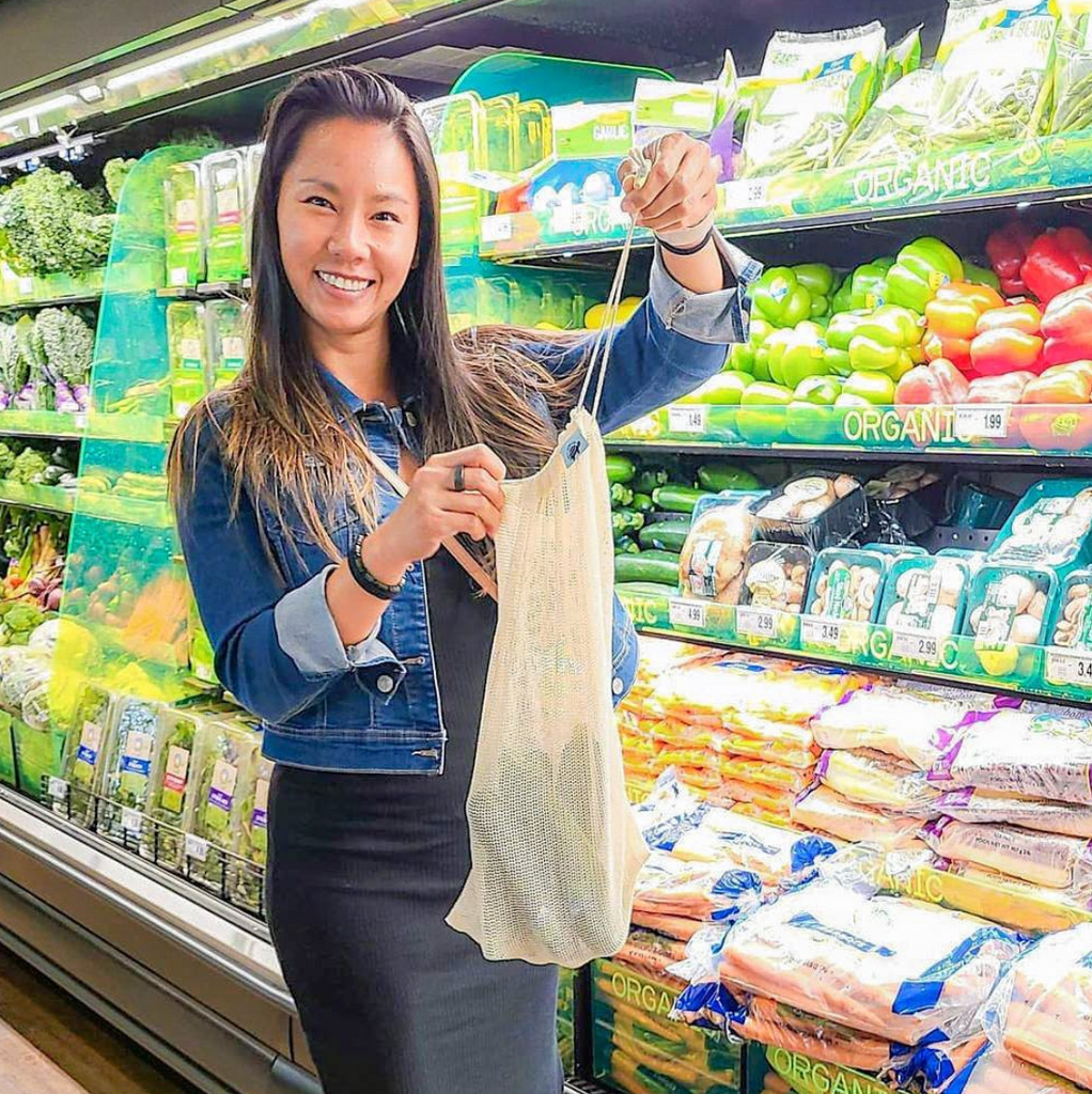 Woman using Net Zero Co resusable mesh produce bags at the grocery store