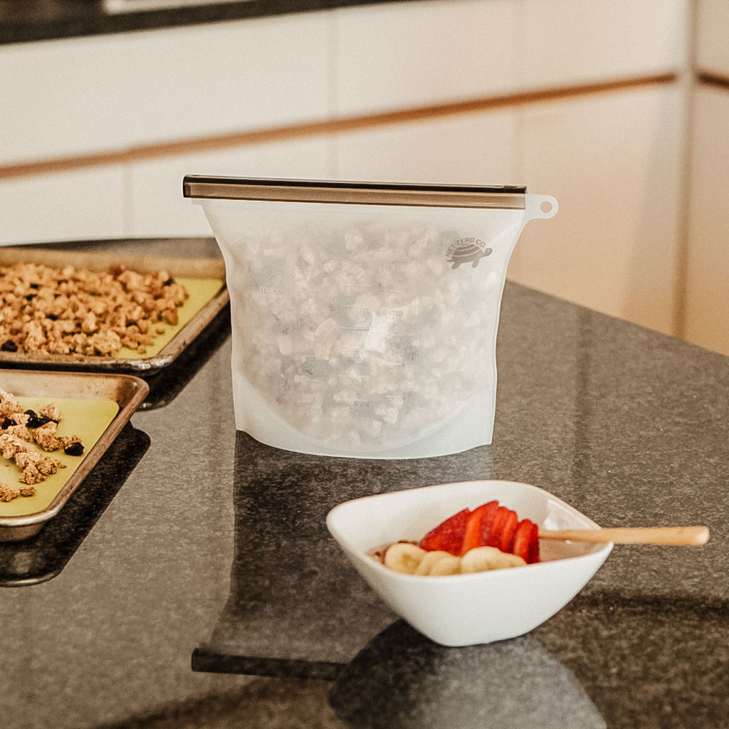 Silicone Sealer Bag Holding Granola Next To Silicone Baking Mats