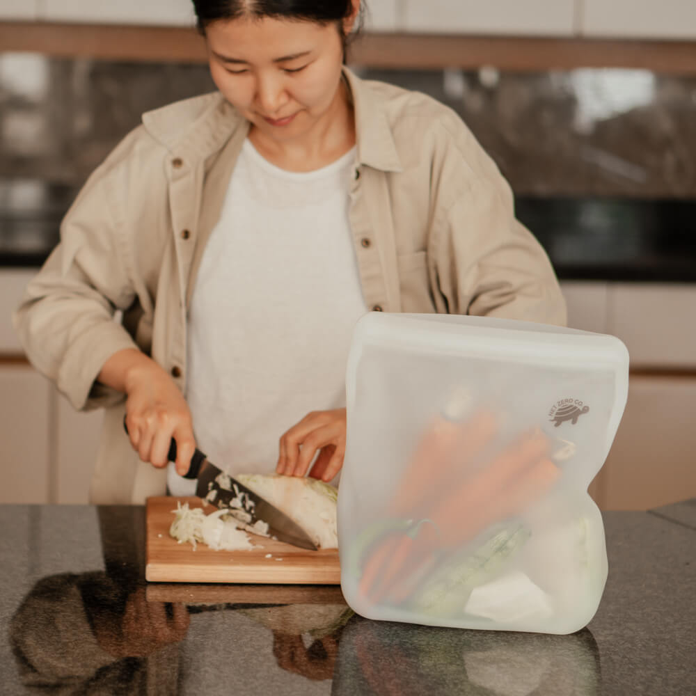 Woman slicing veggies for food prep inside a Silicone Zip Sealer.