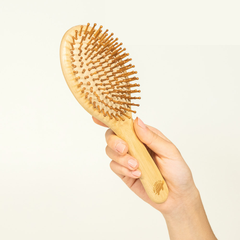 Hand Holding Natural Bamboo Hair Brush